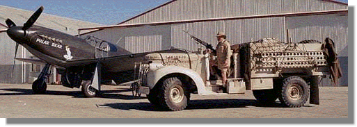 a photo of an LRDG truck alongside a plane